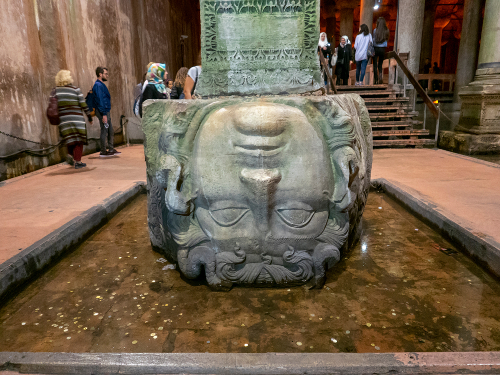 Ancient Roman Medusa head statue positioned upside down at the base of a column in the Basilica Cistern